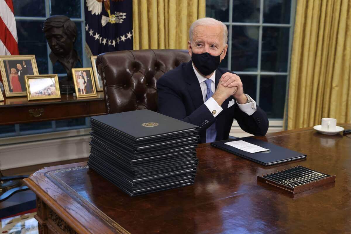 Joe Biden in Oval Office signing first executive orders